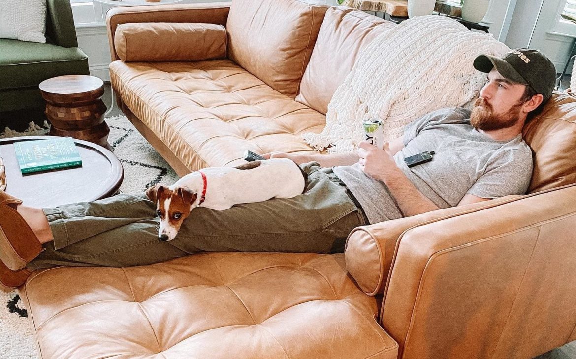 Person lounging with a book on the Article Sven sofa to demonstrate deep, comfortable seating.